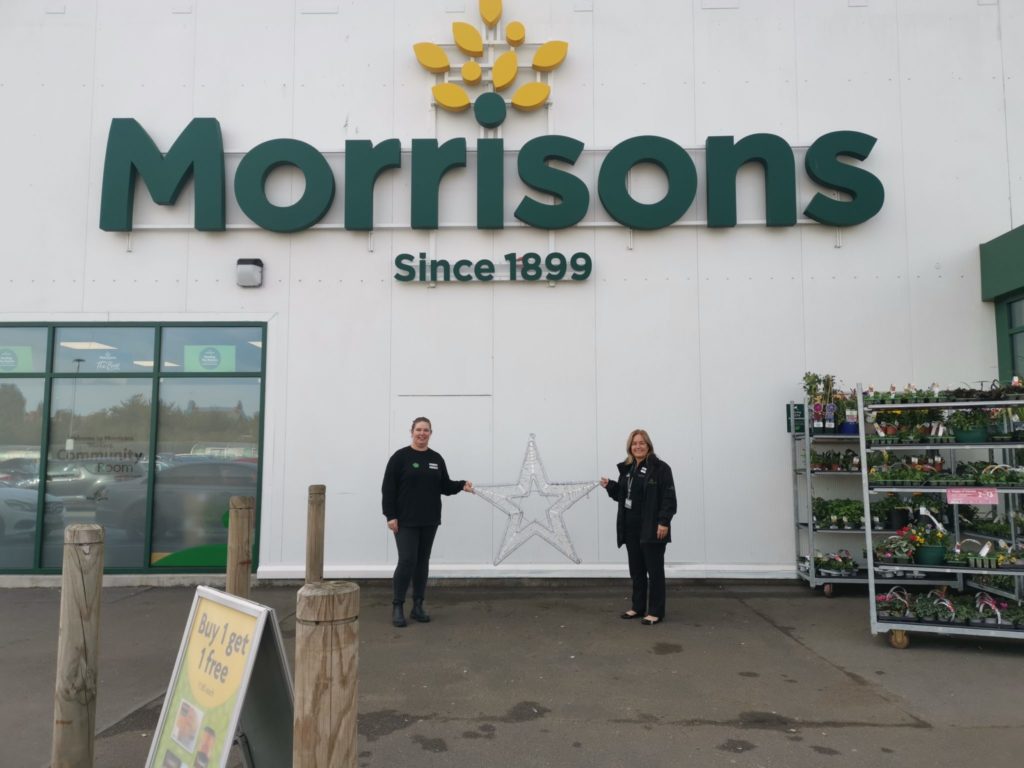 Staff members holding their star outside Morrisons