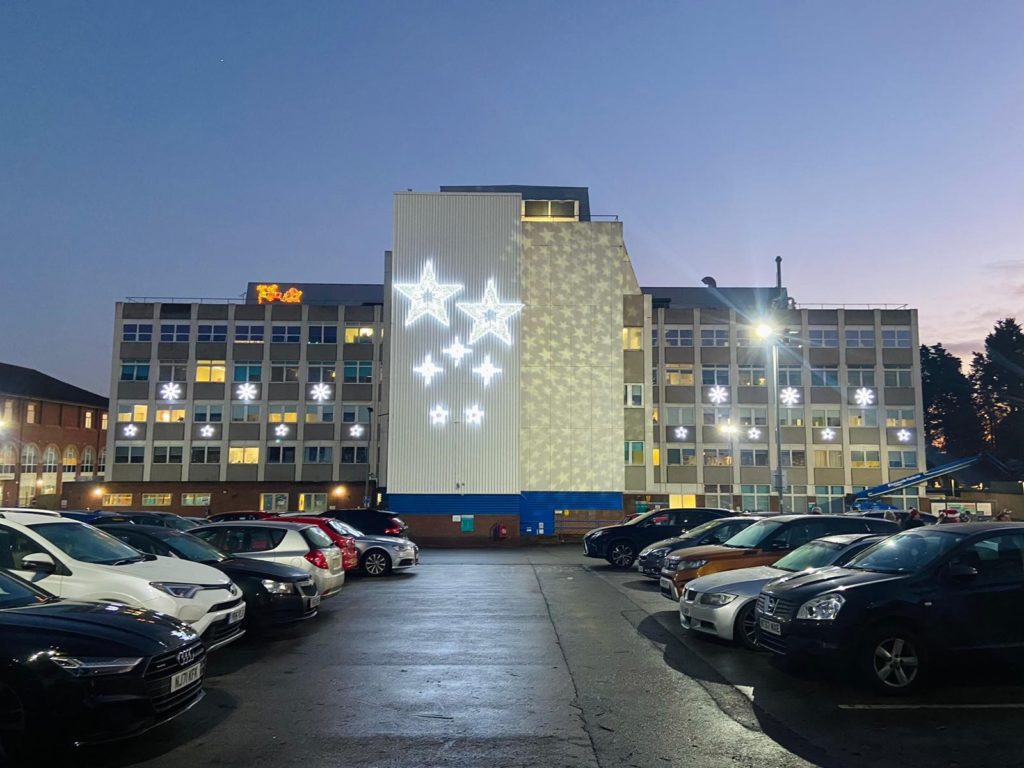 Doncaster Royal Infirmary Christmas stars illuminations to the left, right, and centre of the building. Slightly off centre are the Christmas star illuminations.